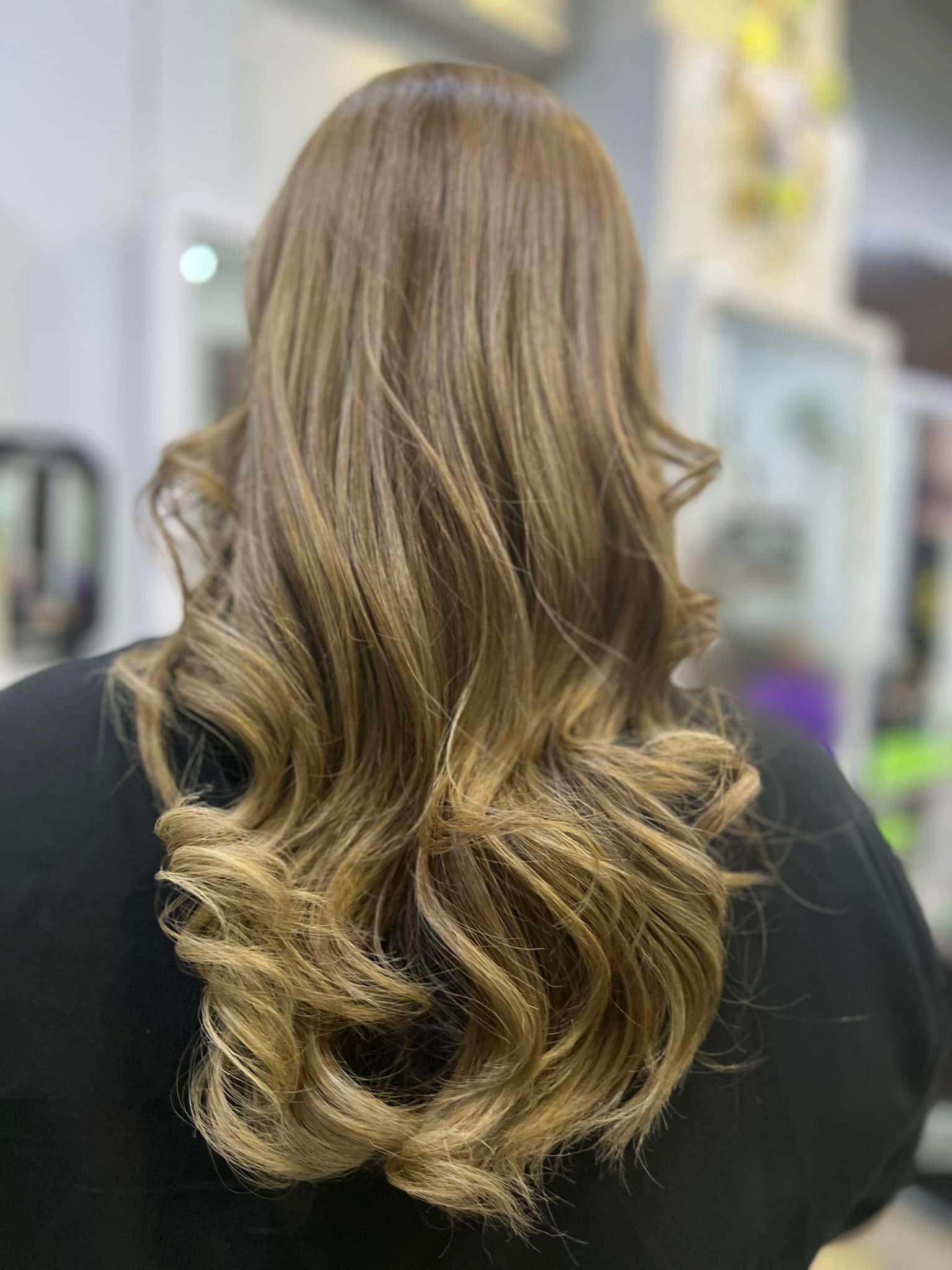 Rambut separas belakang dengan balayage keemasan dan hujung beralun, dilihat dari belakang