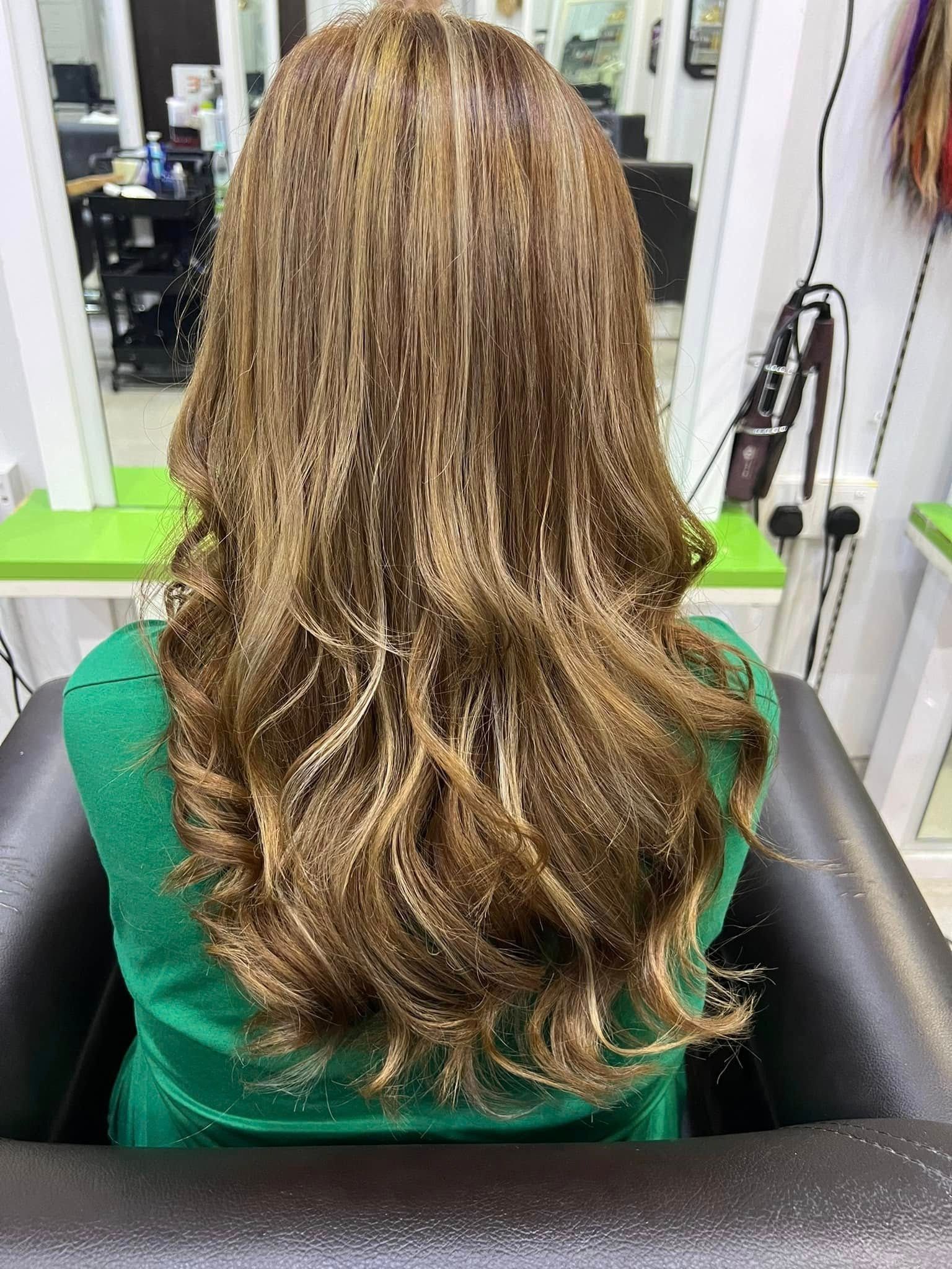 Rambut panjang beralun dengan highlight honey caramel, dilihat dari belakang di stesen Suzee Salon